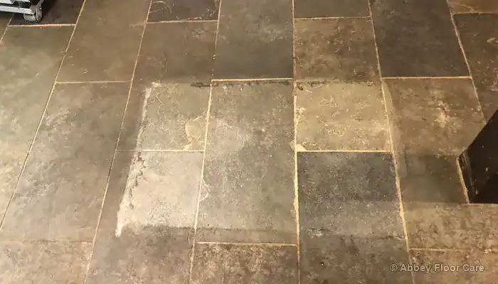 Flat grey dullness across a riven slate floor before restoration